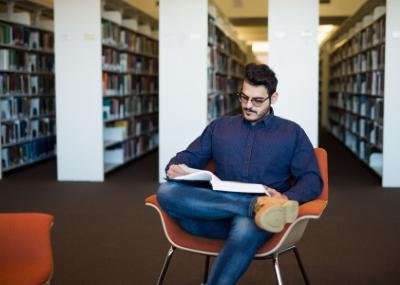 Student reading a book in the library